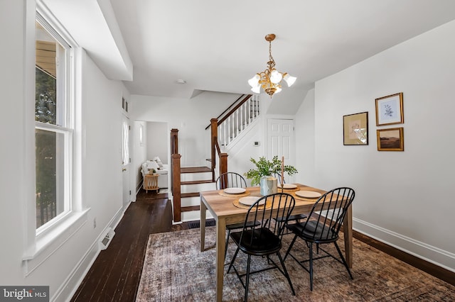 dining space with wood-type flooring, stairs, a notable chandelier, and a healthy amount of sunlight