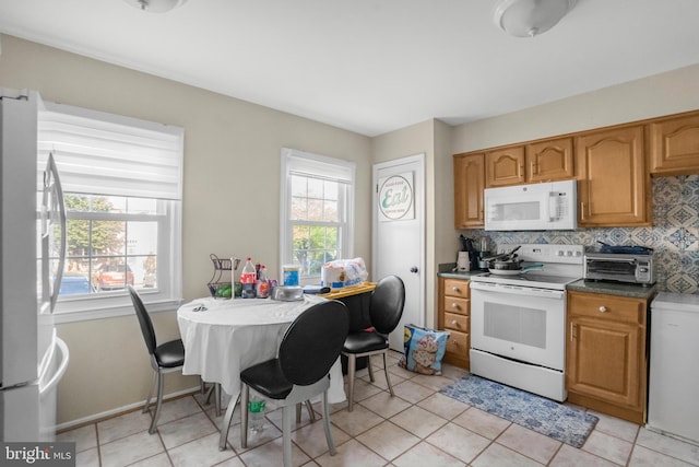 kitchen with tasteful backsplash, brown cabinets, light tile patterned floors, a toaster, and white appliances