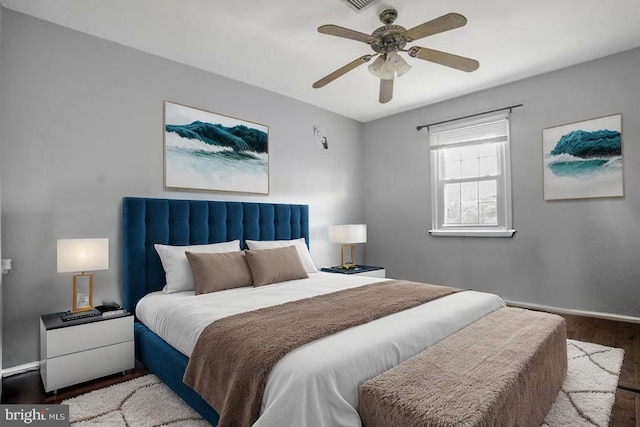 bedroom featuring baseboards, a ceiling fan, wood finished floors, and visible vents