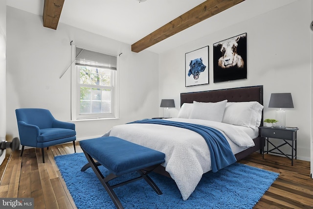 bedroom with wood-type flooring, baseboards, and beam ceiling