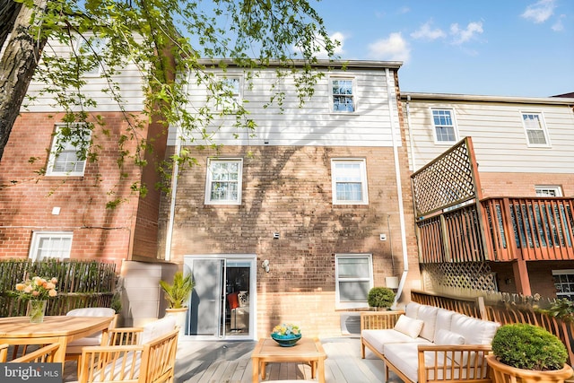 back of house with an outdoor hangout area, a deck, and brick siding