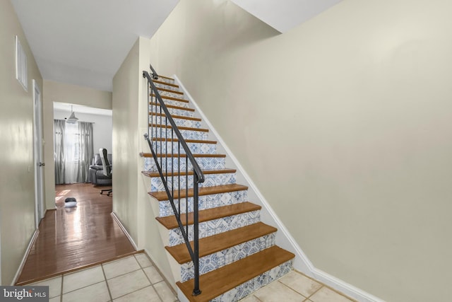 stairs with baseboards and tile patterned flooring