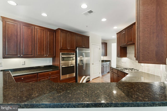 4102 Chariot Way, Upper Marlboro, MD 20772 - kitchen featuring appliances with stainless steel finishes, dark stone counters, recessed lighting, decorative backsplash, and a peninsula
