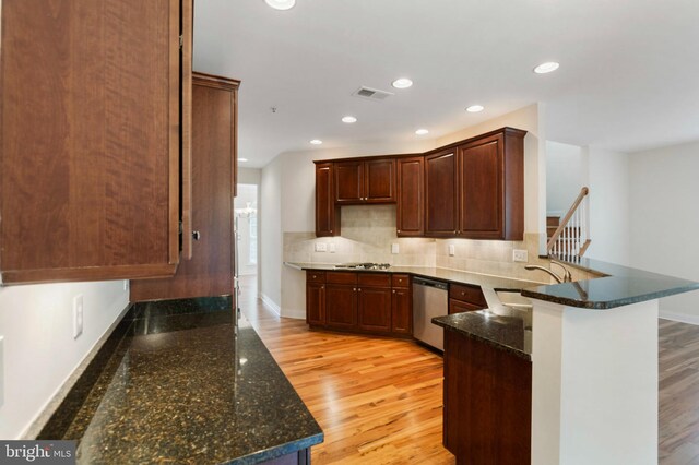 4102 Chariot Way, Upper Marlboro, MD 20772 - kitchen featuring stainless steel appliances, a sink, a peninsula, light wood-style flooring, and decorative backsplash