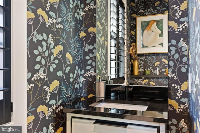 bathroom with a sink and wallpapered walls