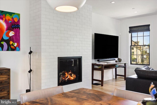 living room with recessed lighting, wood finished floors, and a fireplace