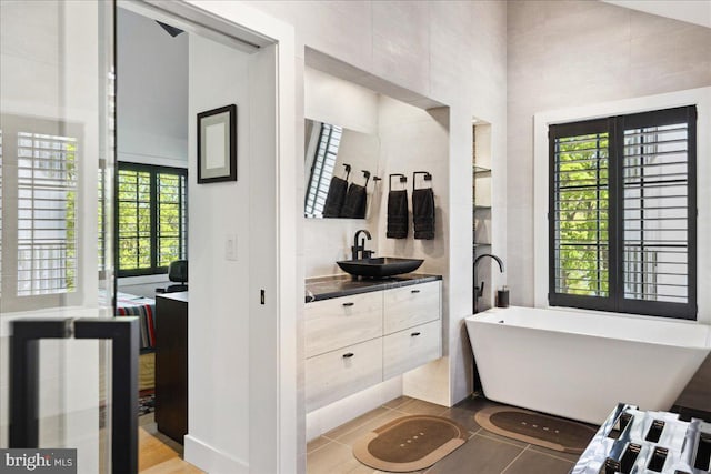 full bathroom featuring vanity, tile patterned floors, and a freestanding bath
