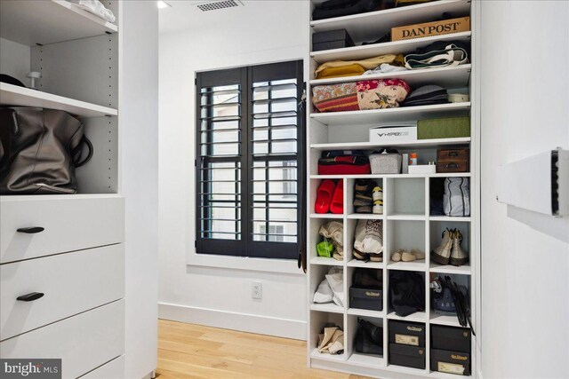 walk in closet with wood finished floors