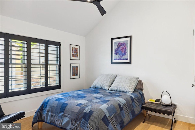 bedroom with baseboards, a ceiling fan, wood finished floors, and high vaulted ceiling