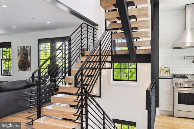 staircase with recessed lighting and wood finished floors