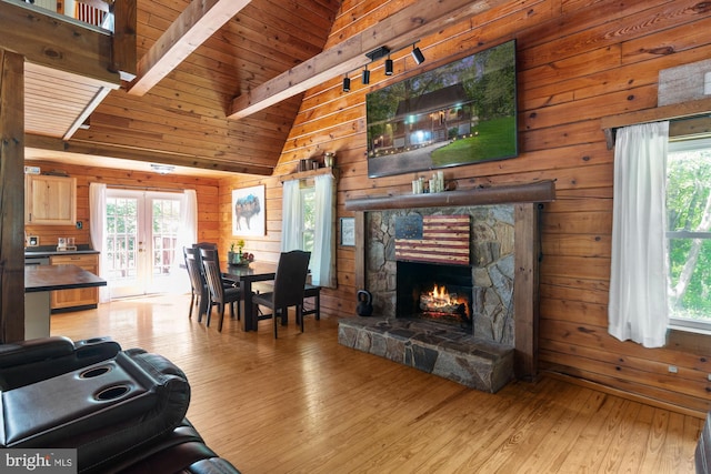 2 Heights Ct, Ruther Glen, VA 22546 - living room featuring wood walls, light wood-type flooring, a stone fireplace, and french doors