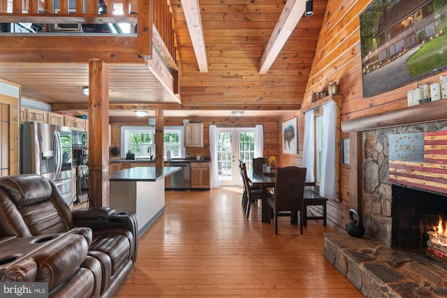 2 Heights Ct, Ruther Glen, VA 22546 - dining space featuring beamed ceiling, light wood-style floors, a stone fireplace, wood walls, and wood ceiling