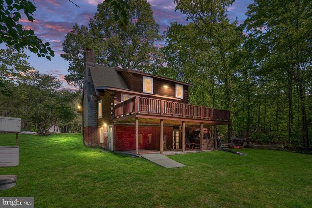 2 Heights Ct, Ruther Glen, VA 22546 - back of house at dusk with a wooden deck, a yard, a chimney, and a patio area