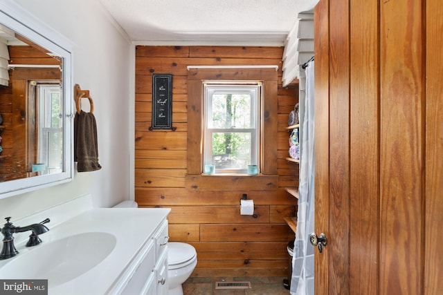 2 Heights Ct, Ruther Glen, VA 22546 - bathroom featuring wood walls, toilet, vanity, and a textured ceiling