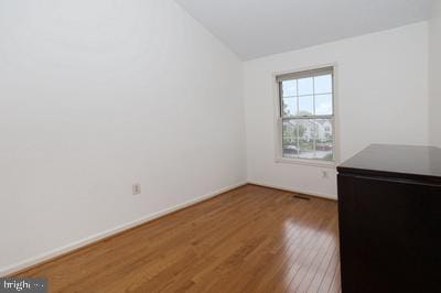 unfurnished room featuring baseboards, vaulted ceiling, and wood finished floors
