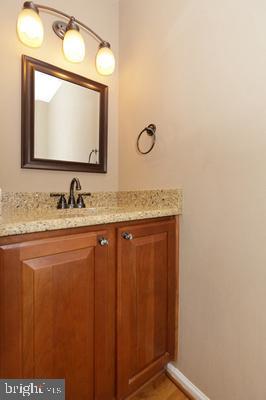 bathroom featuring baseboards, wood finished floors, and vanity