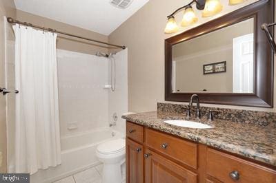 bathroom featuring toilet, vanity, visible vents, tile patterned floors, and shower / tub combo