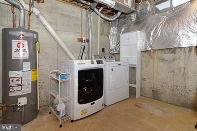 clothes washing area featuring washing machine and clothes dryer, water heater, and laundry area