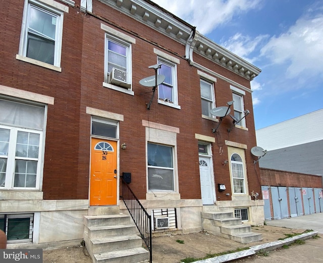 townhome / multi-family property featuring brick siding and entry steps