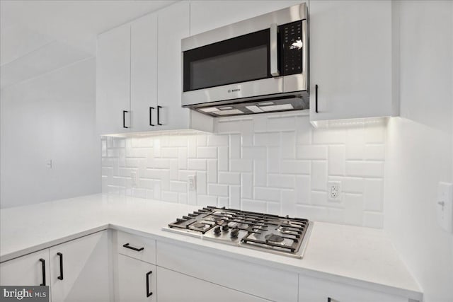 923 V St NW Unit 602, Washington, DC 20001 - kitchen featuring stainless steel appliances, white cabinetry, light countertops, and tasteful backsplash