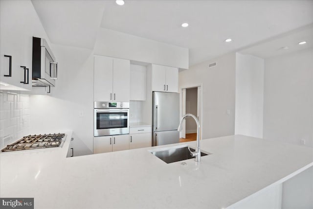 923 V St NW Unit 602, Washington, DC 20001 - kitchen with appliances with stainless steel finishes, tasteful backsplash, a peninsula, recessed lighting, and white cabinets