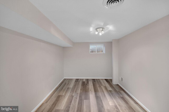 below grade area featuring visible vents, baseboards, and wood finished floors
