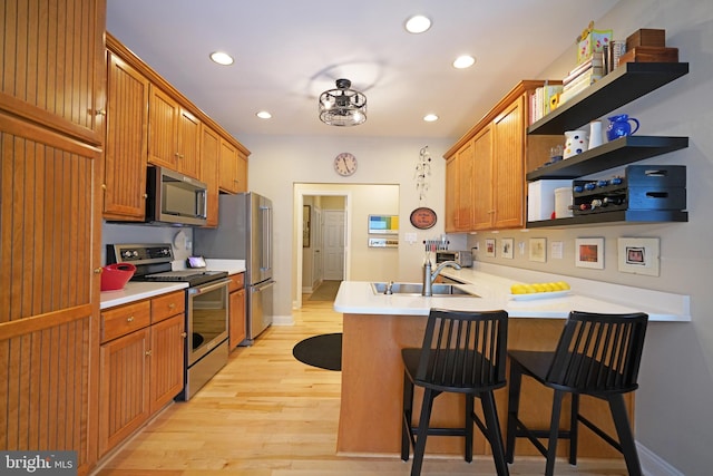 102 Morgan Way, Milton, DE 19968 - kitchen with stainless steel appliances, a sink, a peninsula, recessed lighting, and light wood-type flooring