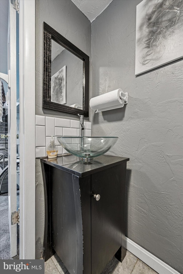 bathroom featuring vanity and a textured wall