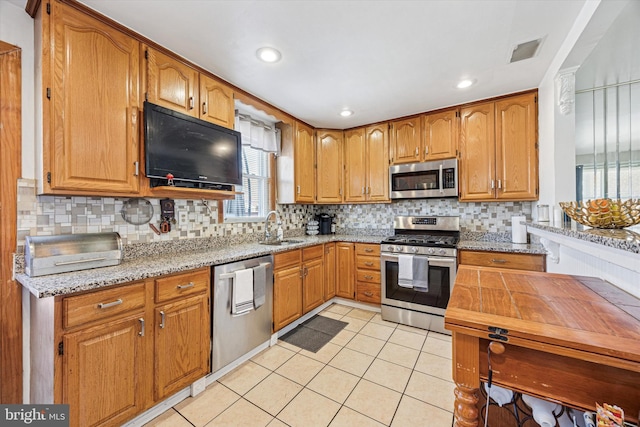 kitchen with visible vents, tasteful backsplash, a sink, stainless steel appliances, and light tile patterned flooring