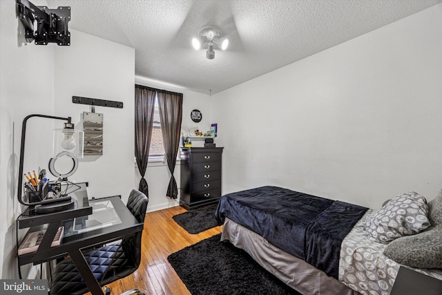 bedroom featuring light wood-type flooring and a textured ceiling