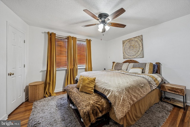 bedroom featuring a ceiling fan, a textured ceiling, and wood finished floors