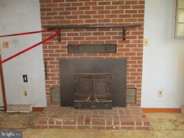 2014 Leland Ave, Baltimore, MD 21220 - room details featuring baseboards, a wood stove, and visible vents