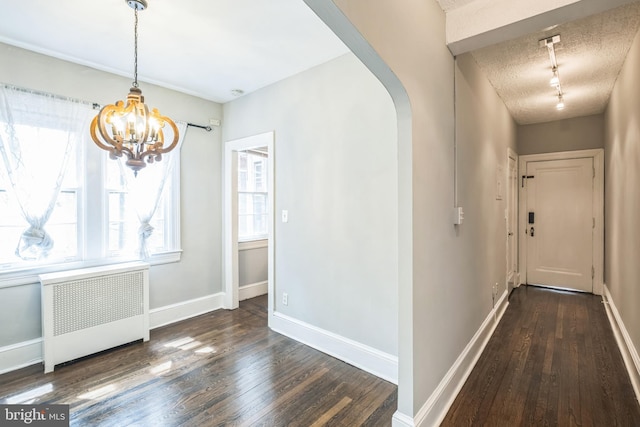 208 Farragut St NW Unit 104, Washington, DC 20011 - hallway with radiator heating unit, hardwood / wood-style floors, a chandelier, arched walkways, and a textured ceiling