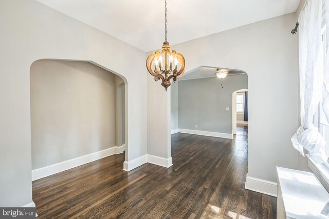 208 Farragut St NW Unit 104, Washington, DC 20011 - unfurnished dining area featuring arched walkways, dark wood-style floors, a chandelier, and baseboards