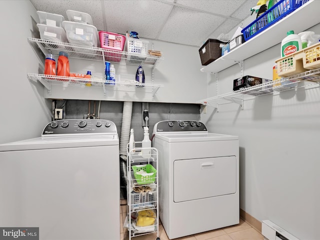 laundry area featuring tile patterned flooring, a baseboard radiator, laundry area, and washer and dryer