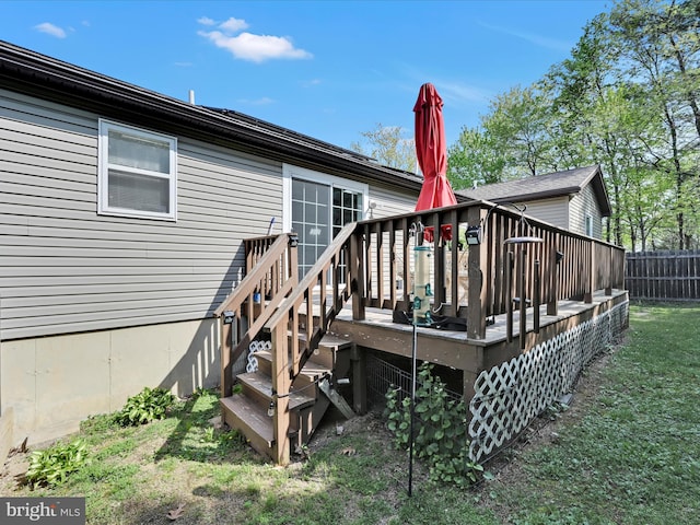 back of house with fence, a yard, and a deck