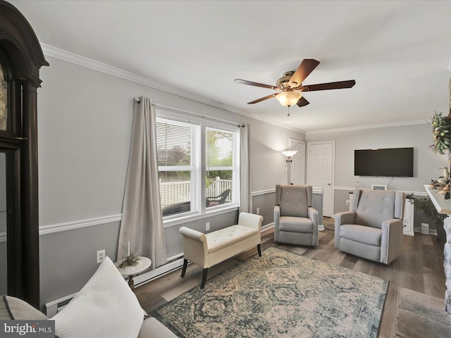 living area with wood finished floors, ornamental molding, ceiling fan, and a baseboard heating unit