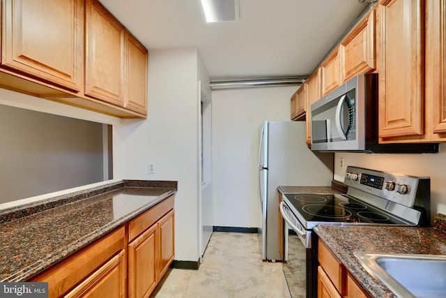 702 S Wolfe St Unit 5, Baltimore, MD 21231 - kitchen with appliances with stainless steel finishes, dark stone countertops, and baseboards