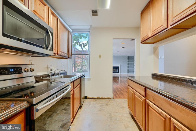 702 S Wolfe St Unit 5, Baltimore, MD 21231 - kitchen featuring appliances with stainless steel finishes, a sink, dark stone counters, and baseboards