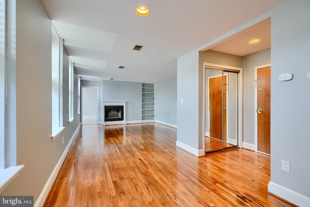 702 S Wolfe St Unit 5, Baltimore, MD 21231 - unfurnished living room featuring light wood finished floors, built in features, baseboards, a fireplace, and recessed lighting