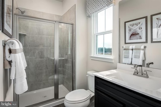 full bathroom featuring vanity, a stall shower, and toilet