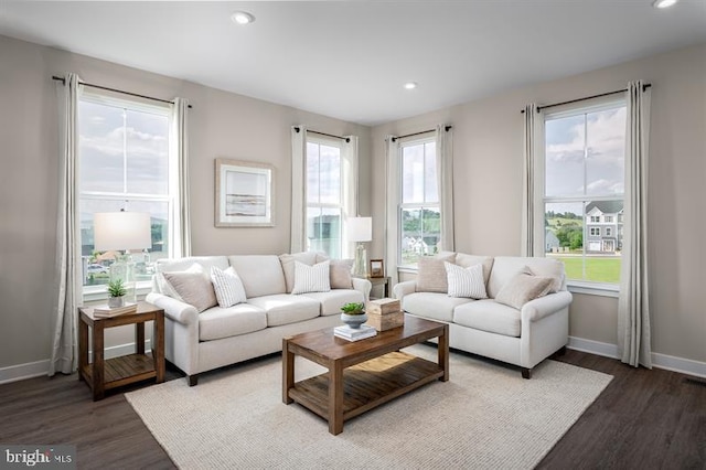 living area with baseboards, recessed lighting, wood finished floors, and a wealth of natural light