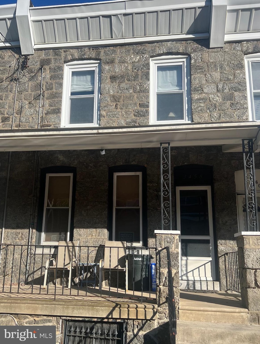 entrance to property with covered porch and stone siding