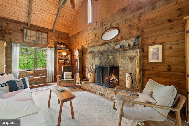 living area with wooden walls, high vaulted ceiling, beamed ceiling, and wood ceiling