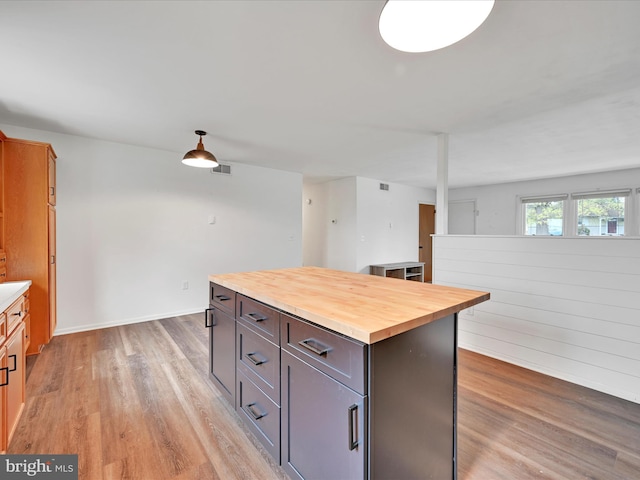 kitchen with visible vents, light wood-style flooring, butcher block counters, and a center island