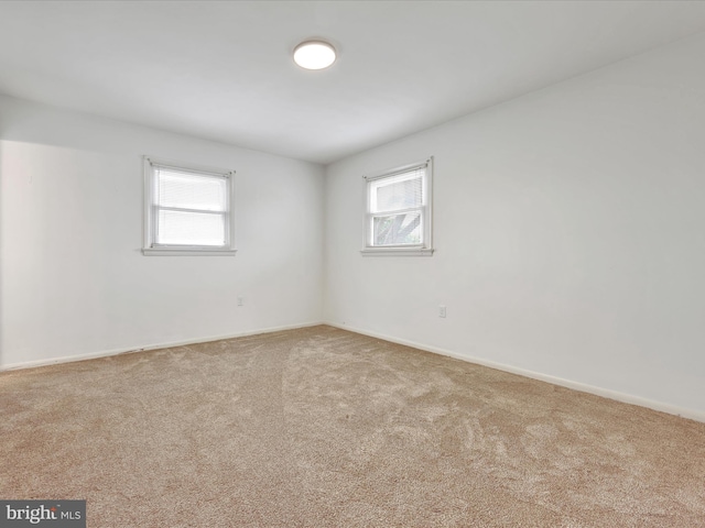 carpeted spare room with baseboards and a healthy amount of sunlight