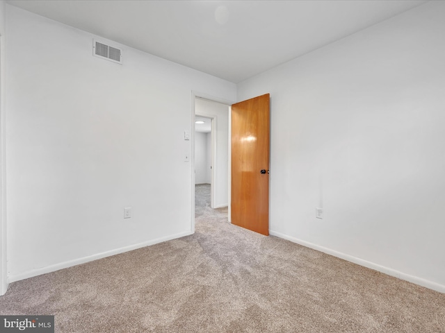 empty room with baseboards, carpet, and visible vents