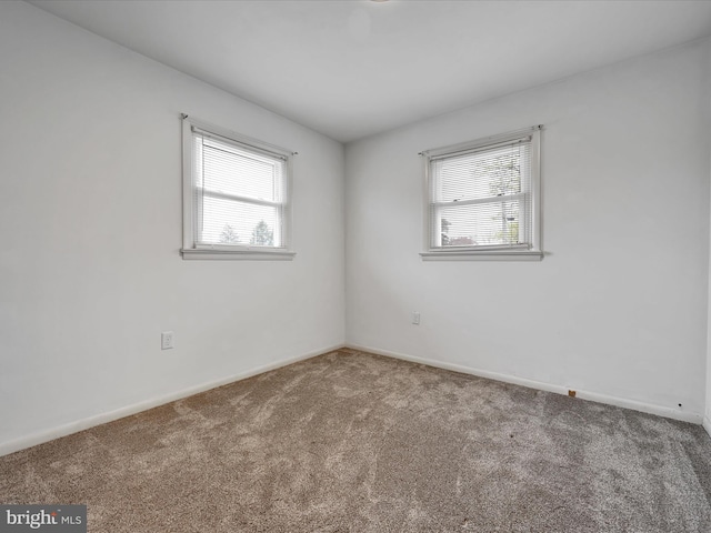 spare room featuring baseboards and carpet