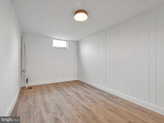 below grade area featuring light wood-style floors and baseboards