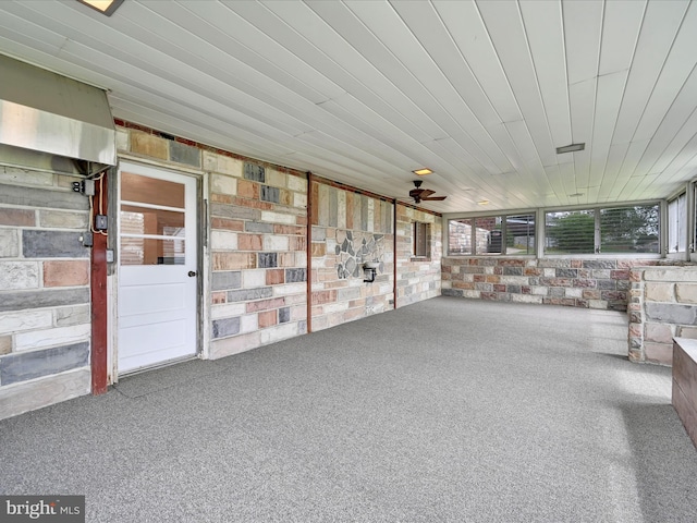 unfurnished sunroom featuring a ceiling fan